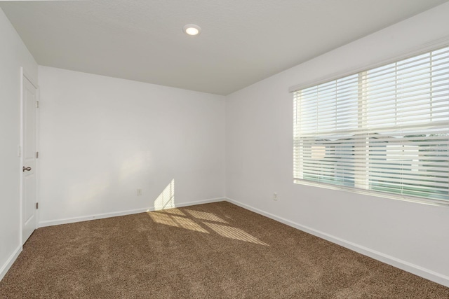 carpeted spare room with baseboards
