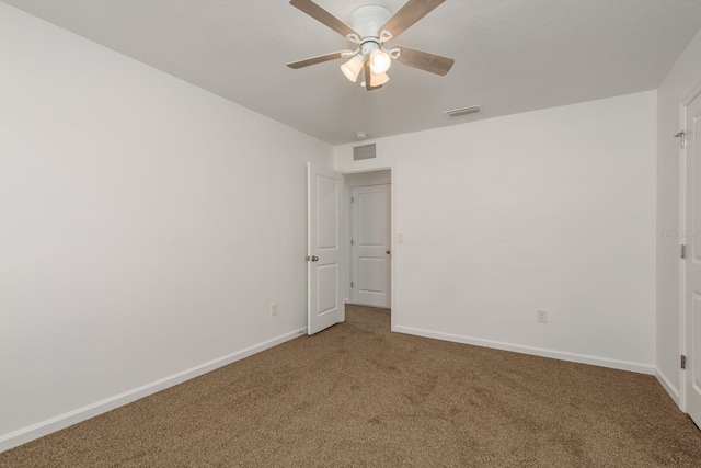 carpeted spare room with ceiling fan and baseboards