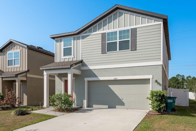 view of front of home with an attached garage, driveway, stucco siding, and board and batten siding