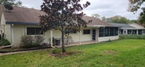 8313 Cavalry Dr, Hudson, FL 34667 - back of house featuring a lawn, a sunroom, and a patio