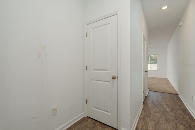 corridor with wood finished floors, baseboards, and recessed lighting