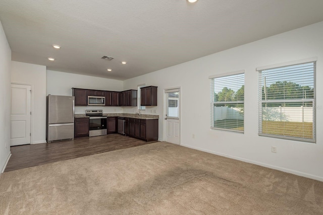 kitchen with stainless steel appliances, dark carpet, baseboards, dark brown cabinetry, and recessed lighting