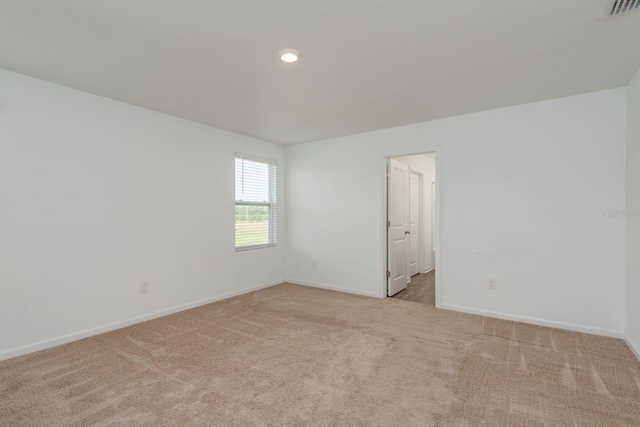spare room featuring light colored carpet, baseboards, and recessed lighting