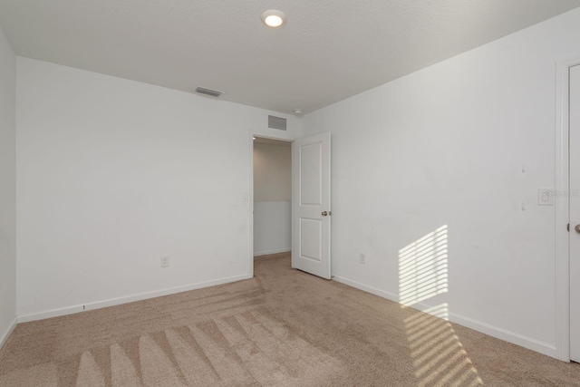 unfurnished room featuring carpet and baseboards
