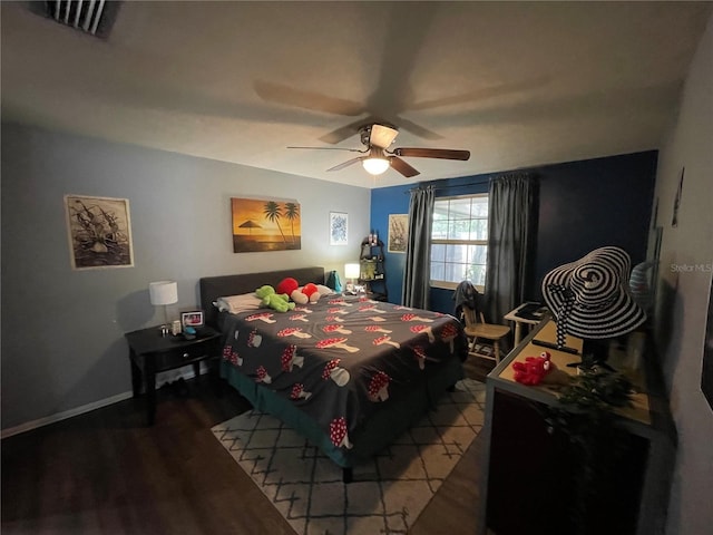 bedroom featuring baseboards, a ceiling fan, wood finished floors, and visible vents