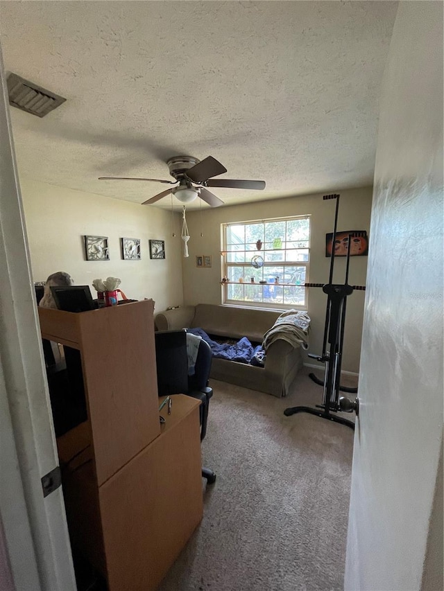 carpeted bedroom featuring a ceiling fan, a textured ceiling, and visible vents
