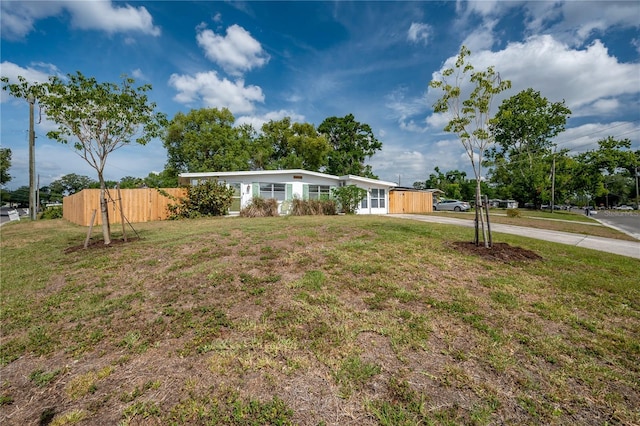 view of yard with fence and driveway