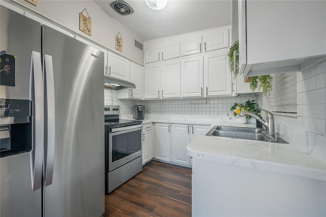kitchen featuring backsplash, appliances with stainless steel finishes, a sink, under cabinet range hood, and white cabinetry