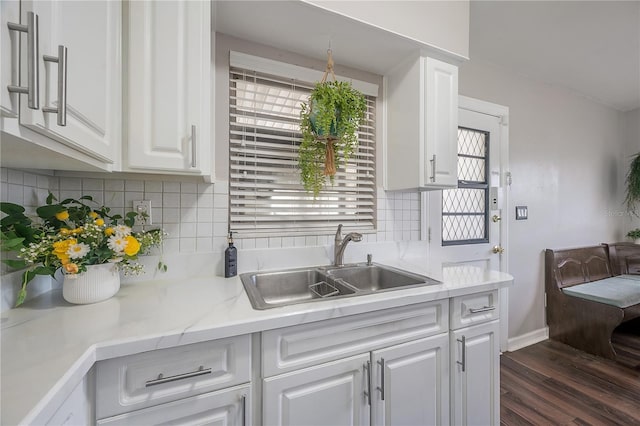 kitchen with a sink, light countertops, white cabinetry, a healthy amount of sunlight, and dark wood-style floors