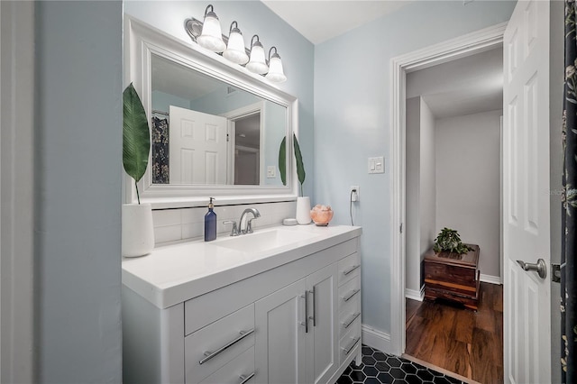 bathroom featuring vanity, decorative backsplash, and wood finished floors