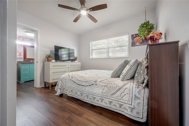 bedroom with ceiling fan, ensuite bathroom, and dark wood-type flooring