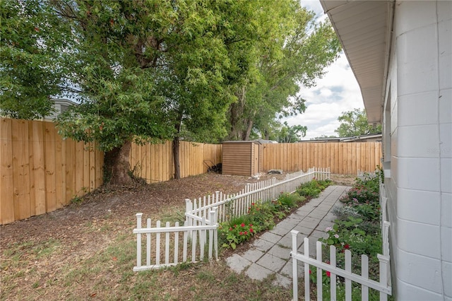 view of yard featuring an outbuilding, a fenced backyard, and a shed