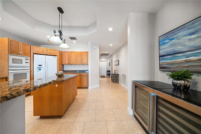 17735 Gulf Blvd Unit 304, Redington Shores, FL 33708 - kitchen featuring white appliances, dark stone counters, beverage cooler, a raised ceiling, and recessed lighting