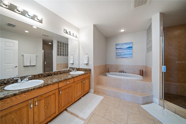 17735 Gulf Blvd Unit 304, Redington Shores, FL 33708 - bathroom featuring tile patterned flooring, a garden tub, double vanity, a stall shower, and recessed lighting
