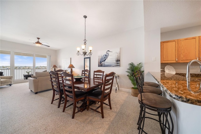 17735 Gulf Blvd Unit 304, Redington Shores, FL 33708 - dining space featuring light carpet, a chandelier, and a ceiling fan