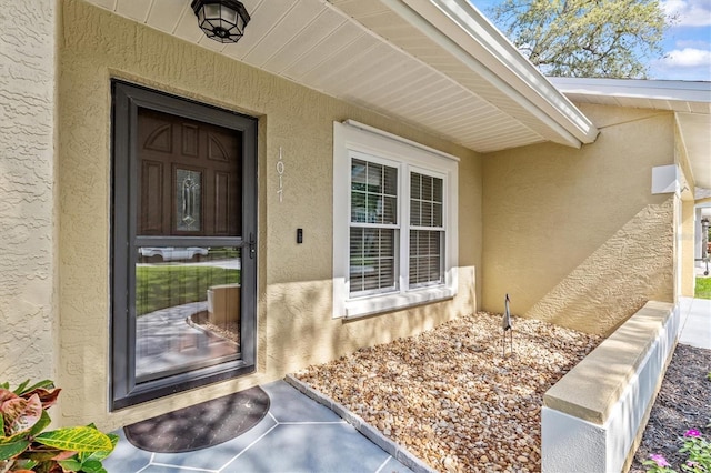 doorway to property featuring stucco siding