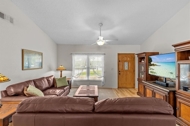 living area featuring a ceiling fan, lofted ceiling, and light wood-style floors
