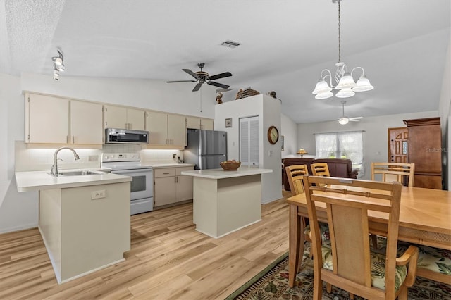 kitchen featuring stainless steel appliances, a sink, vaulted ceiling, ceiling fan, and tasteful backsplash