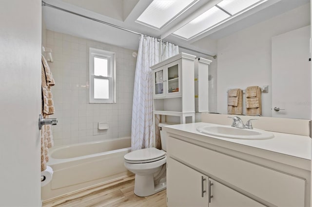 bathroom featuring toilet, wood finished floors, vanity, and shower / bath combo with shower curtain