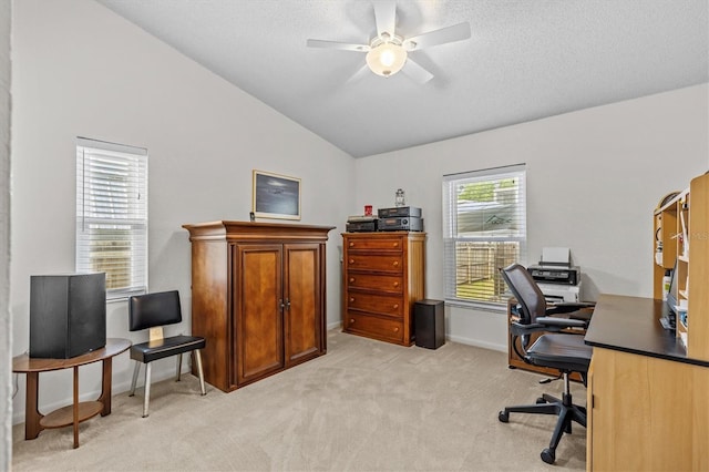 office space with lofted ceiling, ceiling fan, light colored carpet, baseboards, and a textured ceiling