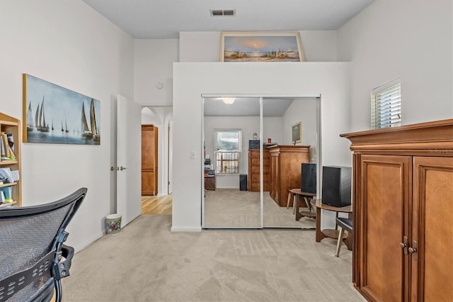 office area featuring light carpet and arched walkways