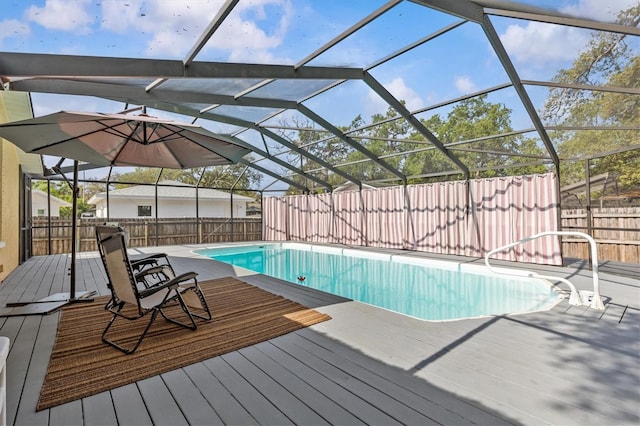 view of swimming pool with a fenced backyard, a deck, and a lanai