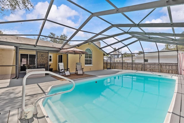 view of pool with fence, a patio, and glass enclosure