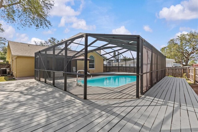 view of pool featuring a fenced backyard, cooling unit, a wooden deck, and a patio area