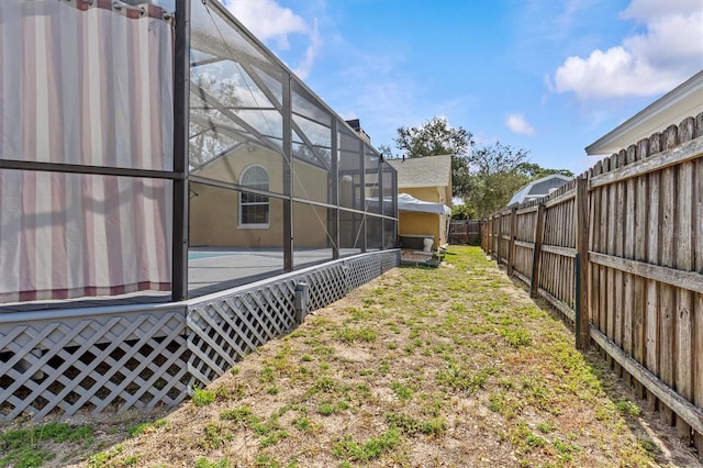 fenced backyard featuring glass enclosure
