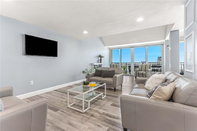 1390 Gulf Blvd Unit Ph-5, Clearwater, FL 33767 - living room featuring light wood-type flooring, recessed lighting, baseboards, and a textured ceiling