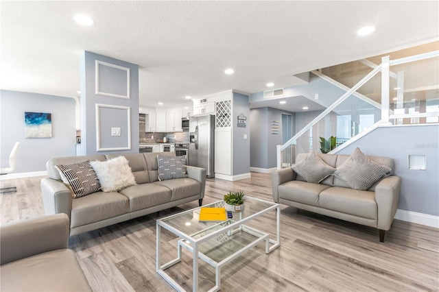 1390 Gulf Blvd Unit Ph-5, Clearwater, FL 33767 - living area with baseboards, stairway, light wood finished floors, and recessed lighting