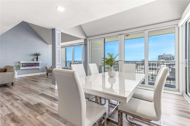 1390 Gulf Blvd Unit Ph-5, Clearwater, FL 33767 - dining room with vaulted ceiling, light wood-style floors, recessed lighting, baseboards, and a textured ceiling