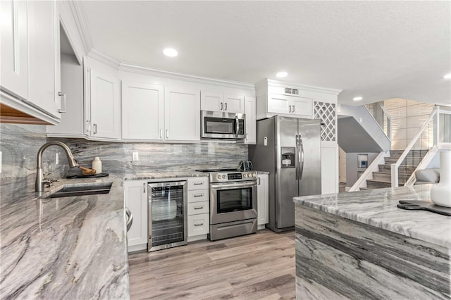 1390 Gulf Blvd Unit Ph-5, Clearwater, FL 33767 - kitchen featuring stainless steel appliances, beverage cooler, a sink, white cabinets, and recessed lighting