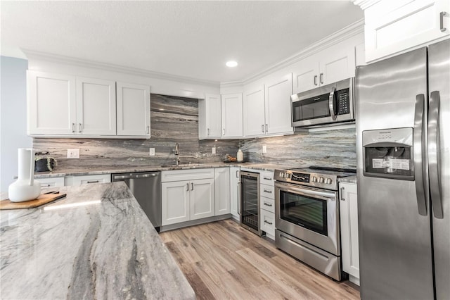 1390 Gulf Blvd Unit Ph-5, Clearwater, FL 33767 - kitchen with appliances with stainless steel finishes, wine cooler, a sink, white cabinetry, and backsplash
