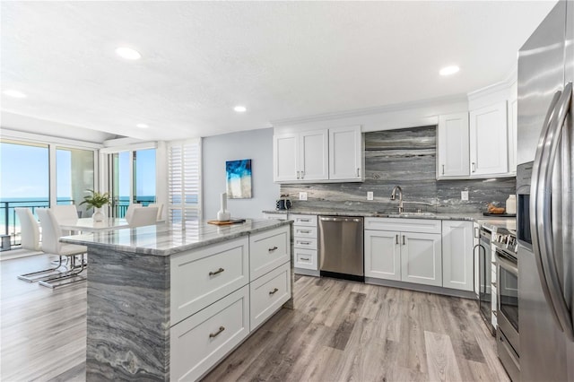 1390 Gulf Blvd Unit Ph-5, Clearwater, FL 33767 - kitchen with appliances with stainless steel finishes, tasteful backsplash, light wood-type flooring, a sink, and recessed lighting
