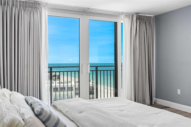 1390 Gulf Blvd Unit Ph-5, Clearwater, FL 33767 - bedroom featuring view of water and beach, wood finished floors, and baseboards