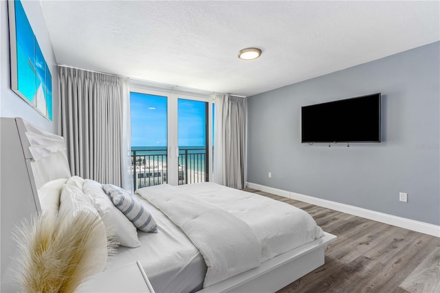1390 Gulf Blvd Unit Ph-5, Clearwater, FL 33767 - bedroom featuring wood finished floors, baseboards, and access to outside