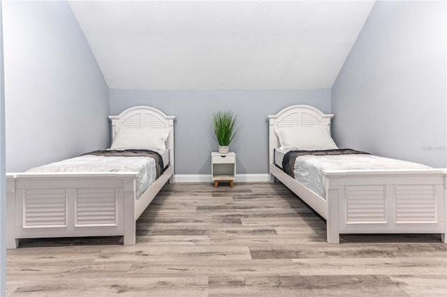 1390 Gulf Blvd Unit Ph-5, Clearwater, FL 33767 - bedroom featuring lofted ceiling, wood finished floors, and baseboards