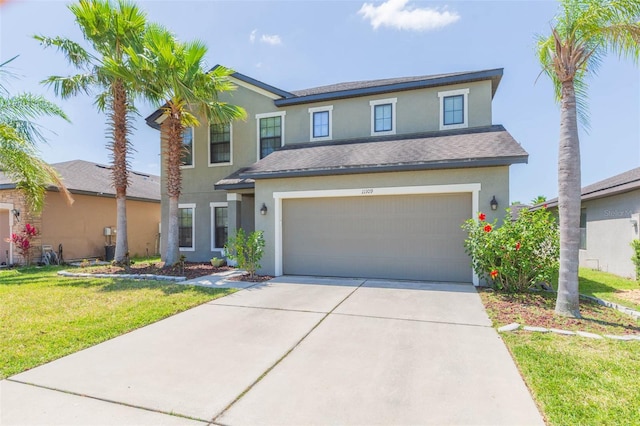 traditional home with a garage, a front lawn, stucco siding, a shingled roof, and concrete driveway