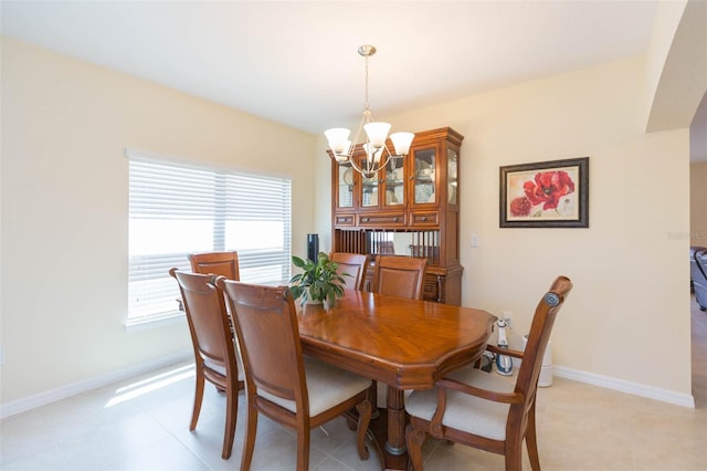 dining area featuring baseboards and a notable chandelier