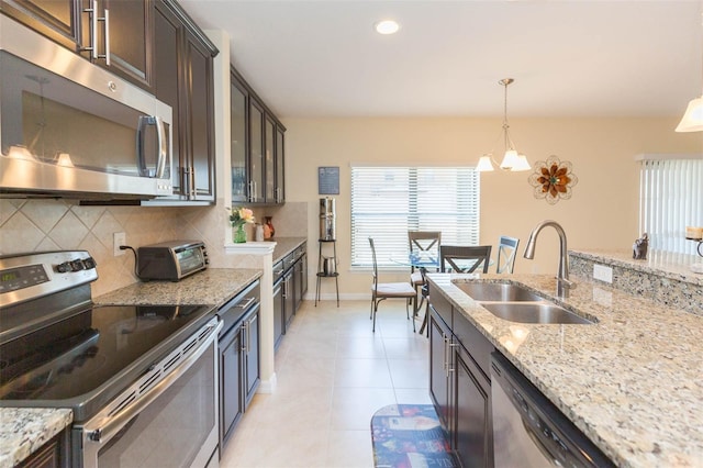 kitchen featuring plenty of natural light, a sink, decorative backsplash, and appliances with stainless steel finishes