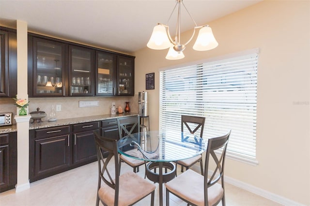 dining area featuring baseboards, a chandelier, and light tile patterned floors