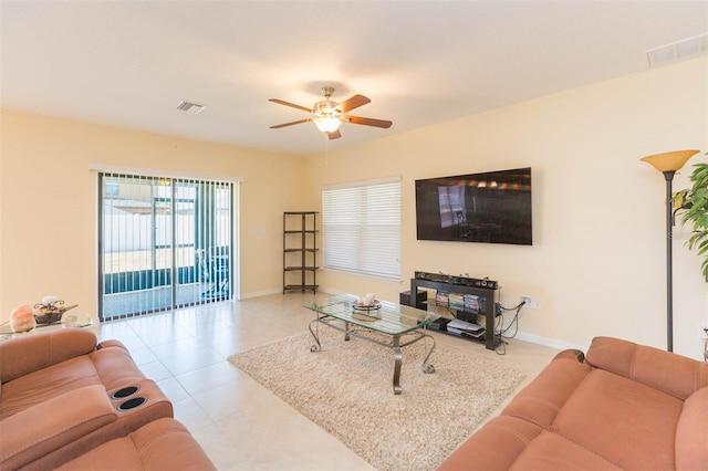 living area with baseboards, ceiling fan, tile patterned flooring, and visible vents
