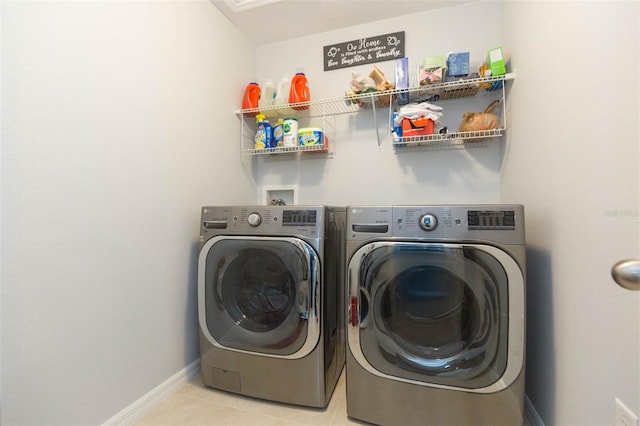 washroom featuring baseboards, laundry area, washer and clothes dryer, and tile patterned flooring