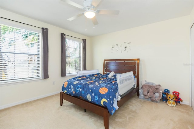 carpeted bedroom featuring baseboards and ceiling fan
