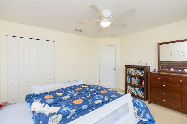 carpeted bedroom with ceiling fan, a closet, and visible vents