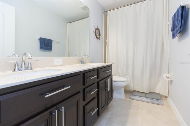 bathroom featuring a sink, tile patterned floors, toilet, and double vanity