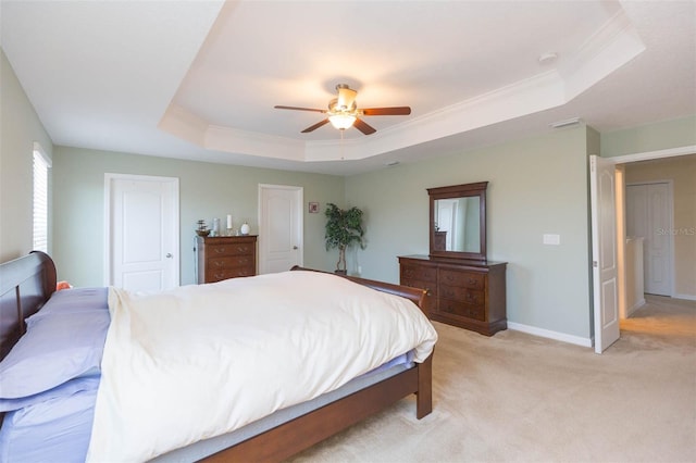 bedroom with crown molding, ceiling fan, light carpet, a raised ceiling, and baseboards