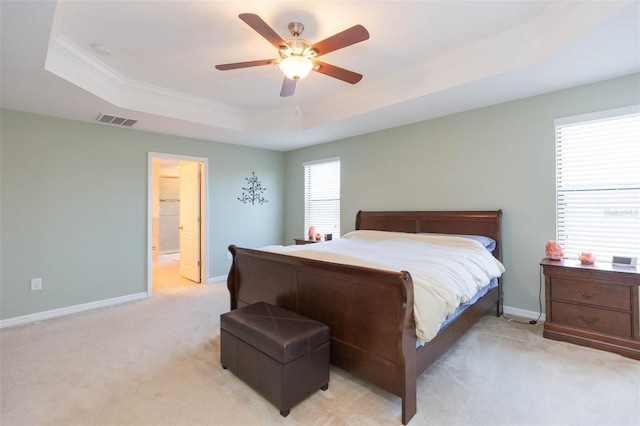 bedroom featuring light colored carpet, visible vents, a raised ceiling, baseboards, and ornamental molding