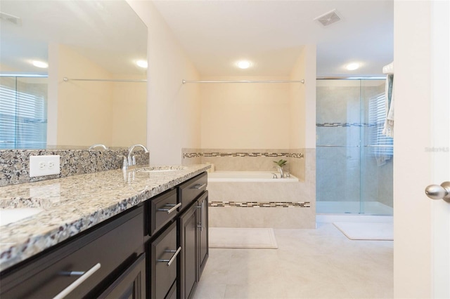 bathroom with a sink, double vanity, tile patterned floors, a shower stall, and visible vents